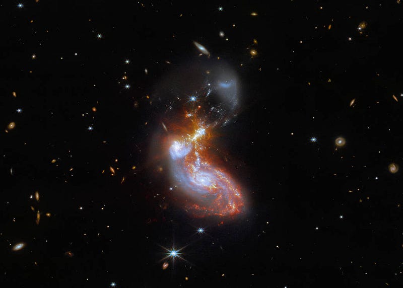 "Together, two merging galaxies form a bean-like shape just below the center of this image..."